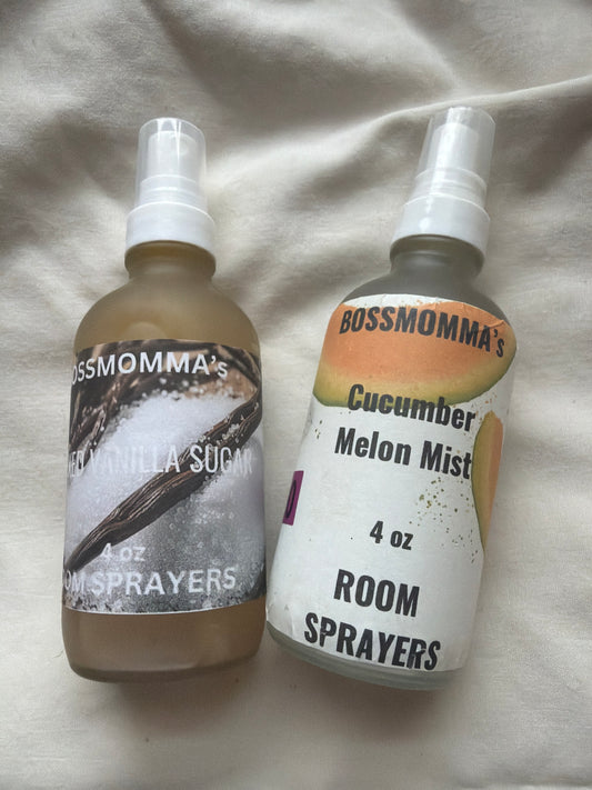 Two room sprayer bottles with labels on a light fabric background