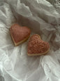 Two heart-shaped soaps on crumpled white paper