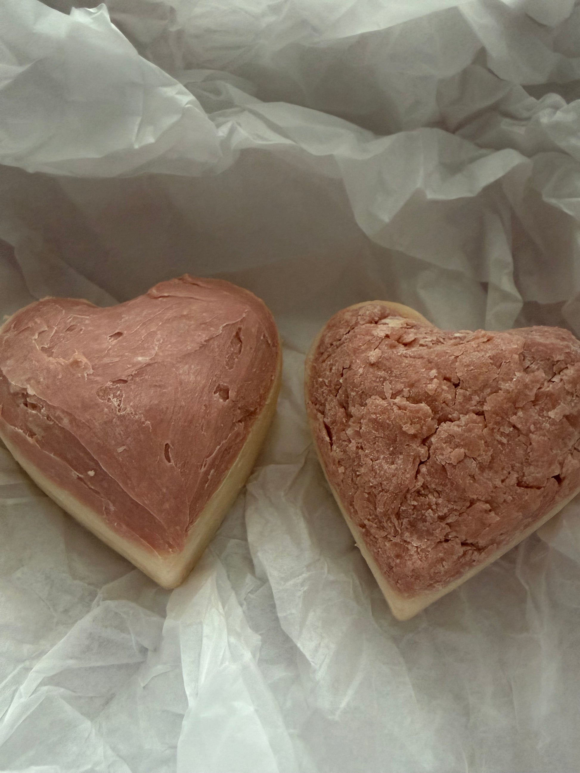Two heart-shaped soaps on a white paper background