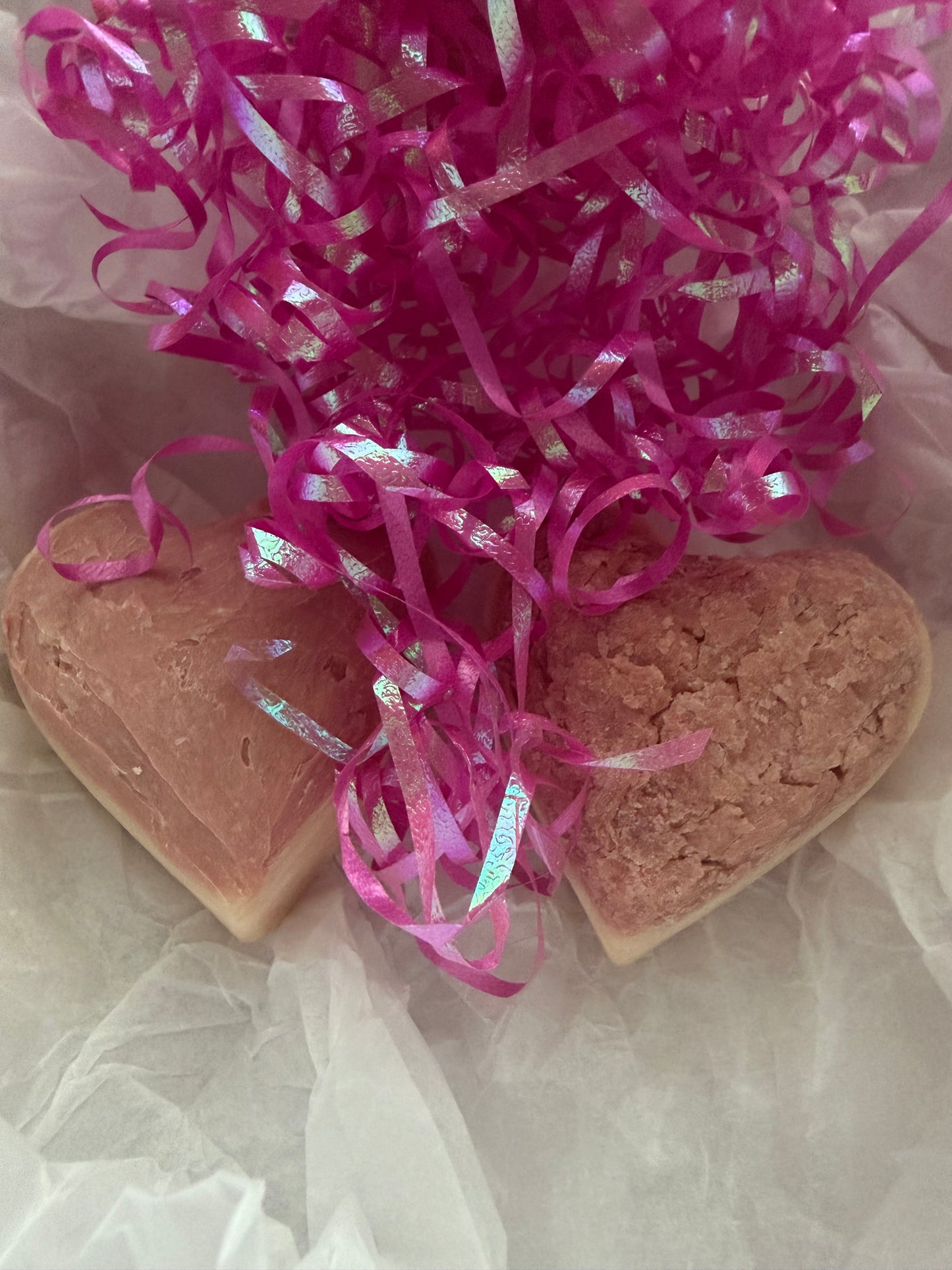 Heart-shaped soaps with pink ribbons on a light background