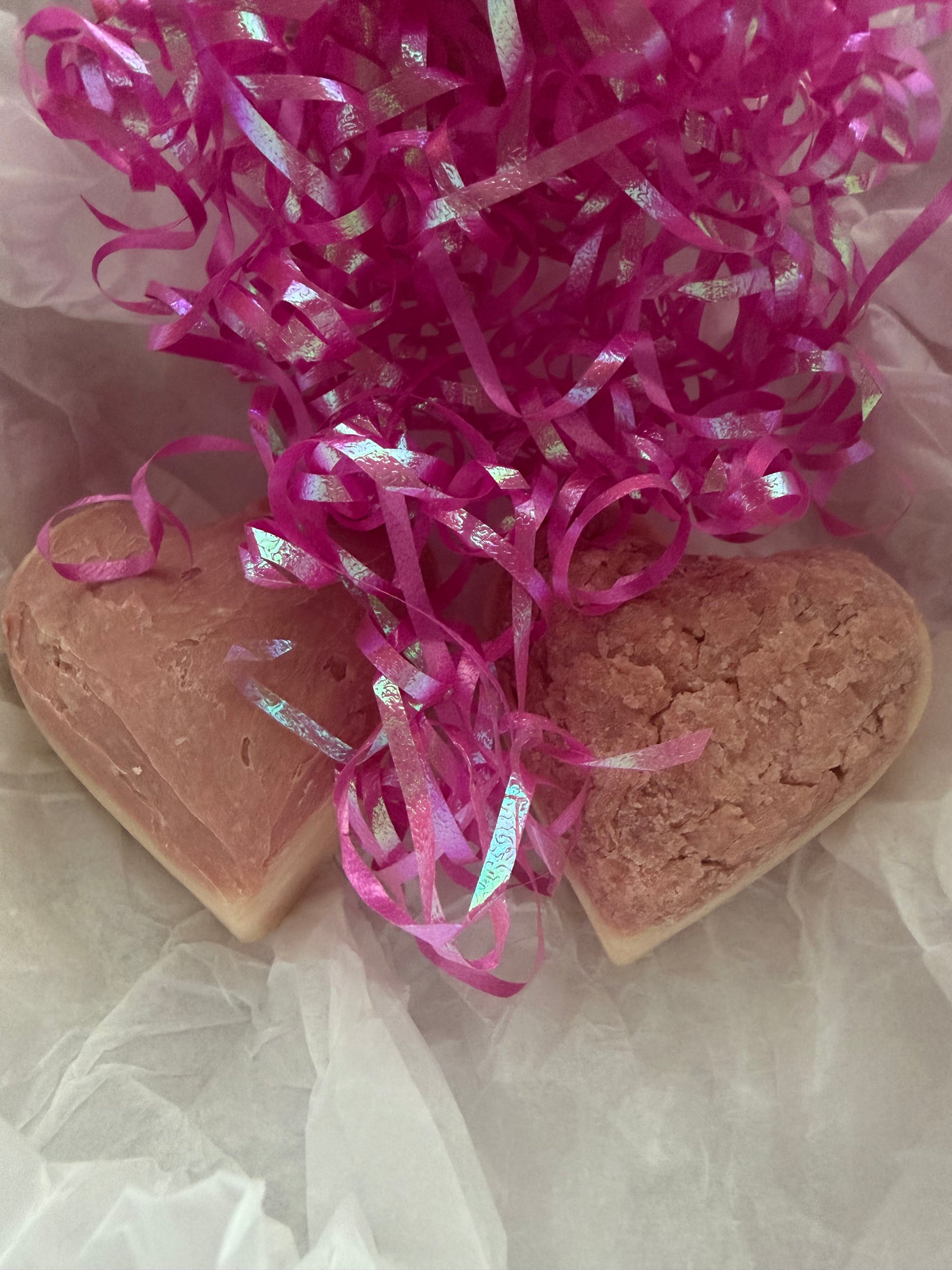 Heart-shaped soaps with pink ribbons on a light background